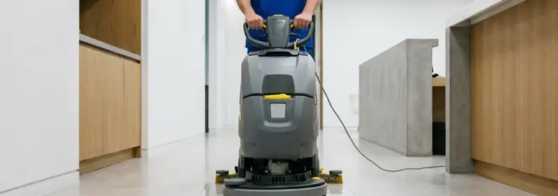 Janitorial staff using a floor scrubber machine to clean a commercial hallway, Scottsdale, AZ.